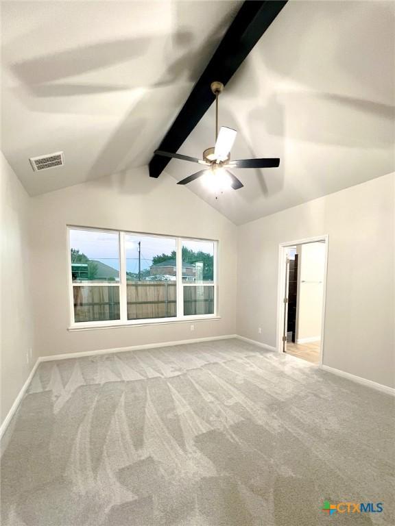 empty room featuring carpet flooring, ceiling fan, and lofted ceiling with beams