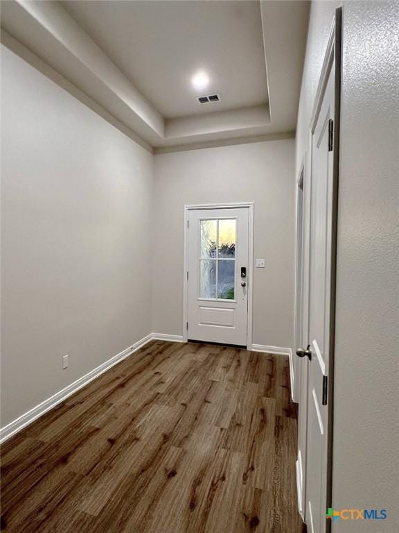 entryway with a tray ceiling and hardwood / wood-style flooring