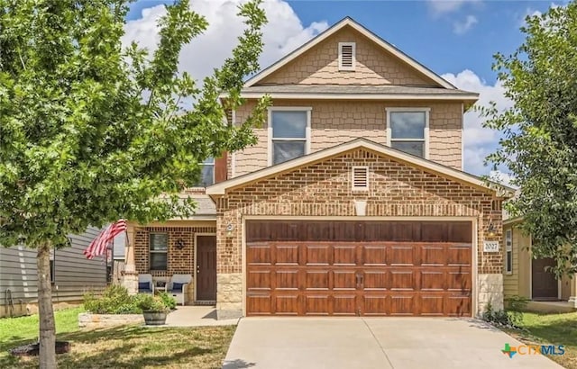 view of front of home with a garage, concrete driveway, and brick siding