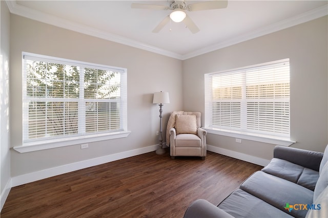 sitting room featuring dark wood-type flooring, ornamental molding, and ceiling fan