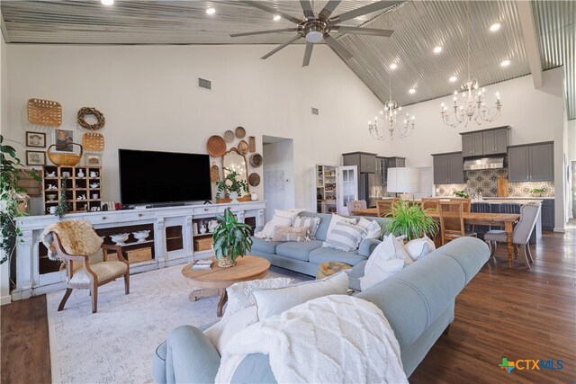 living room with high vaulted ceiling, dark hardwood / wood-style flooring, and ceiling fan with notable chandelier