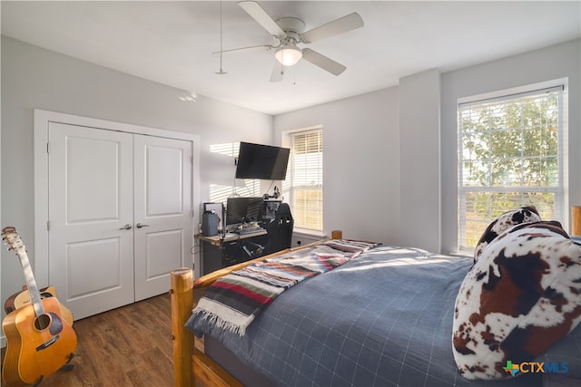 bedroom featuring dark wood-type flooring, a closet, and ceiling fan