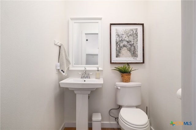 bathroom featuring wood-type flooring and toilet