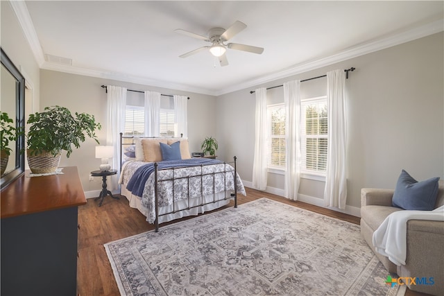 bedroom featuring dark hardwood / wood-style floors, ceiling fan, multiple windows, and crown molding