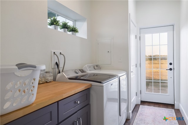 laundry area with cabinets, dark hardwood / wood-style flooring, electric panel, and washing machine and clothes dryer