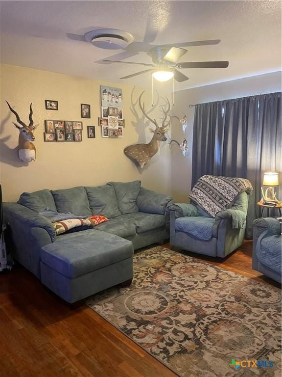 living room with wood-type flooring and ceiling fan