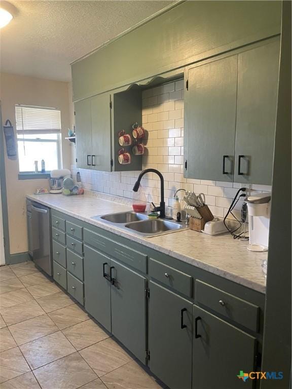 kitchen with sink, dishwasher, backsplash, a textured ceiling, and light tile patterned flooring