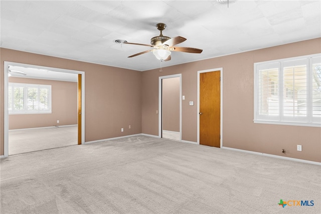 spare room featuring light carpet and ceiling fan