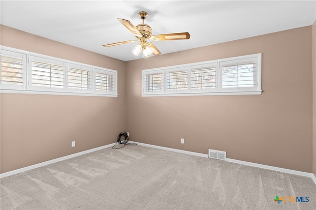 empty room with light carpet, plenty of natural light, and ceiling fan