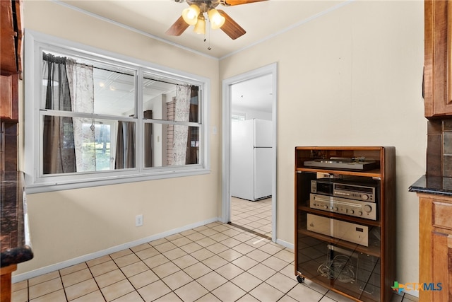 kitchen featuring ceiling fan, white fridge, light tile patterned flooring, and crown molding