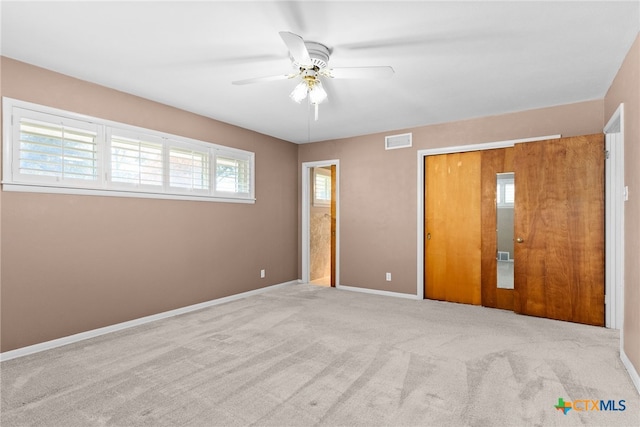 unfurnished bedroom with ceiling fan and light colored carpet