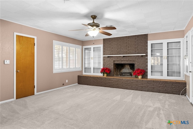 unfurnished living room featuring carpet, ceiling fan, and a brick fireplace