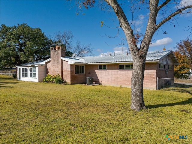 rear view of property with a yard and central AC