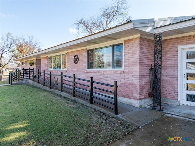 view of side of home with a yard