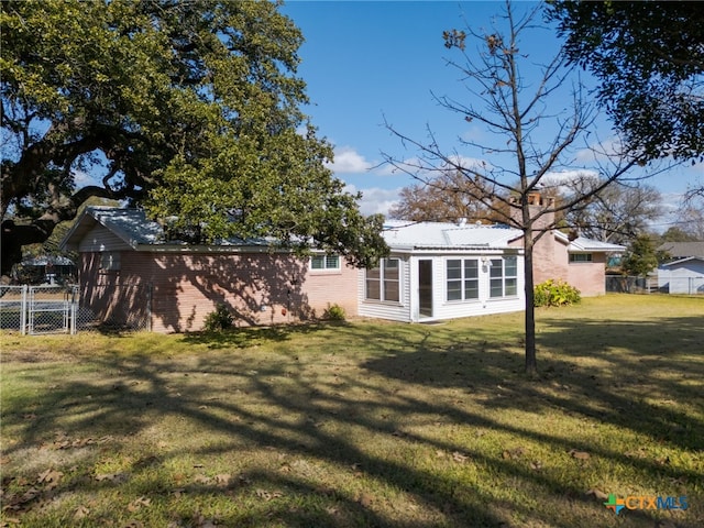 rear view of property featuring a lawn