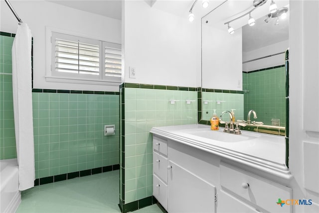 bathroom featuring shower / bath combo, vanity, and tile walls