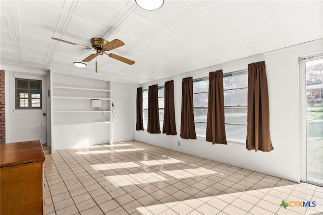 unfurnished sunroom featuring ceiling fan