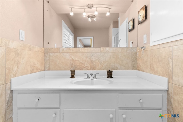 bathroom featuring vanity and tile walls