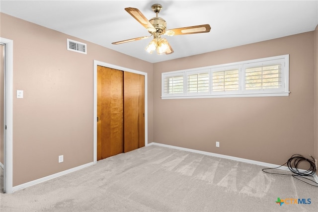 unfurnished bedroom featuring carpet flooring, ceiling fan, and a closet