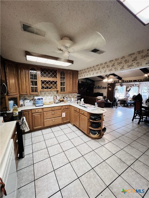 kitchen with kitchen peninsula, a textured ceiling, light tile patterned floors, and ceiling fan