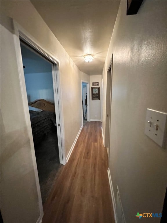 hallway with hardwood / wood-style floors