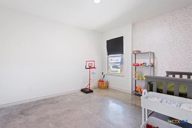 bedroom with concrete floors and a nursery area