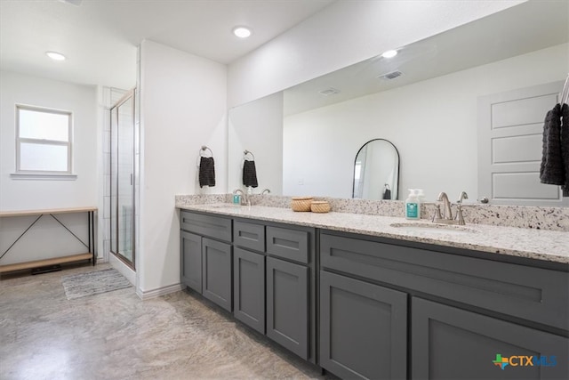 bathroom with a shower with door and vanity