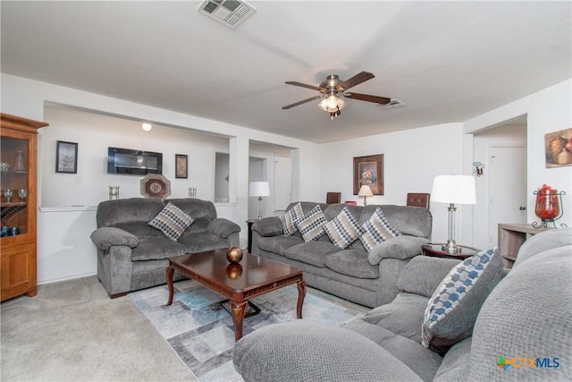 carpeted living room with ceiling fan