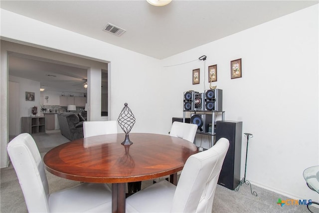 carpeted dining room featuring ceiling fan