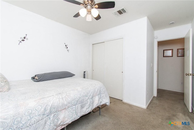 carpeted bedroom with ceiling fan and a closet