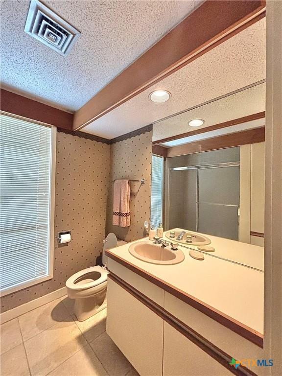 full bathroom featuring visible vents, vanity, a textured ceiling, tile patterned floors, and a shower stall