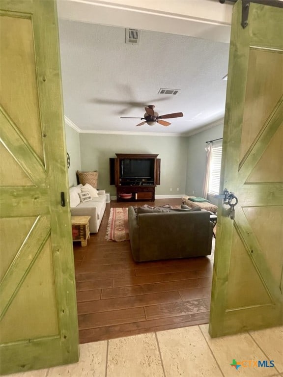 living room with ceiling fan and crown molding