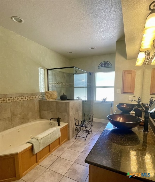 bathroom with vanity, shower with separate bathtub, a textured ceiling, and tile patterned floors