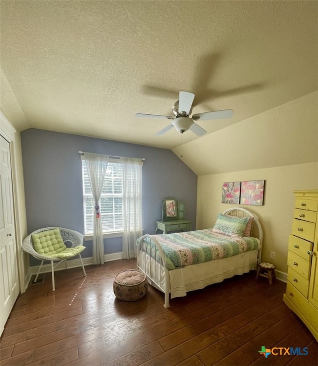 bedroom with ceiling fan, dark hardwood / wood-style flooring, and a textured ceiling