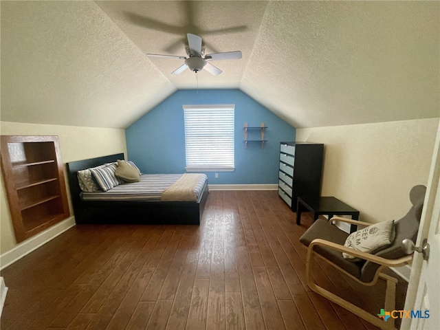 bedroom with dark hardwood / wood-style flooring, a textured ceiling, vaulted ceiling, and ceiling fan