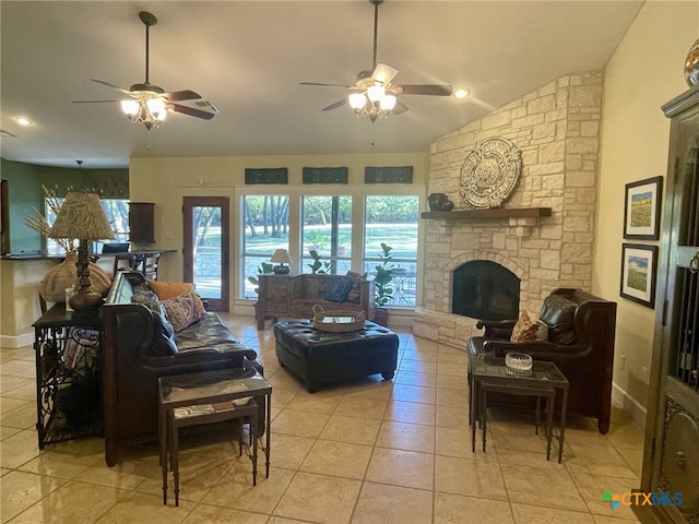 tiled living room featuring a stone fireplace, ceiling fan, and lofted ceiling