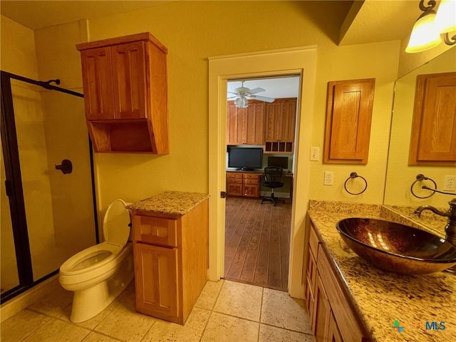 bathroom featuring ceiling fan, vanity, an enclosed shower, and toilet