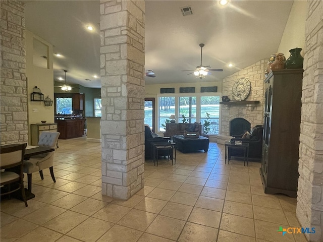 tiled living room with ornate columns, ceiling fan, a fireplace, and lofted ceiling