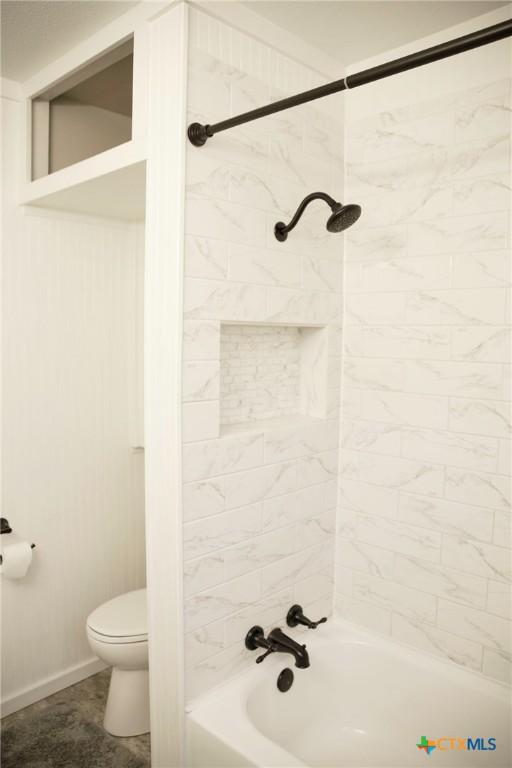 full bathroom featuring toilet, shower / tub combination, and baseboards