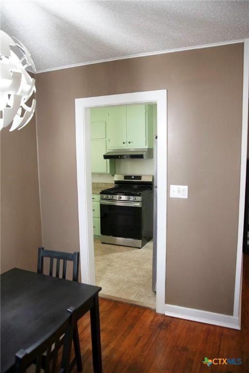 dining area with baseboards, a textured ceiling, and light wood-style floors