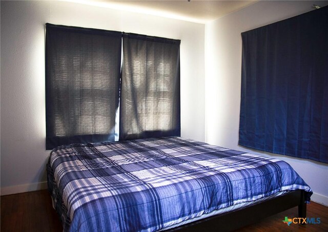 bedroom featuring baseboards and wood finished floors