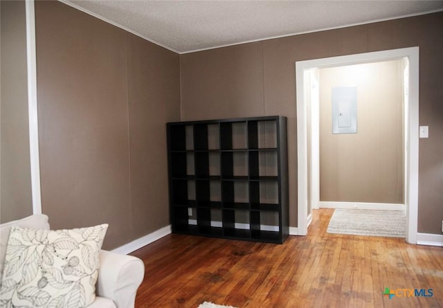 entryway with electric panel, a textured ceiling, baseboards, and wood-type flooring