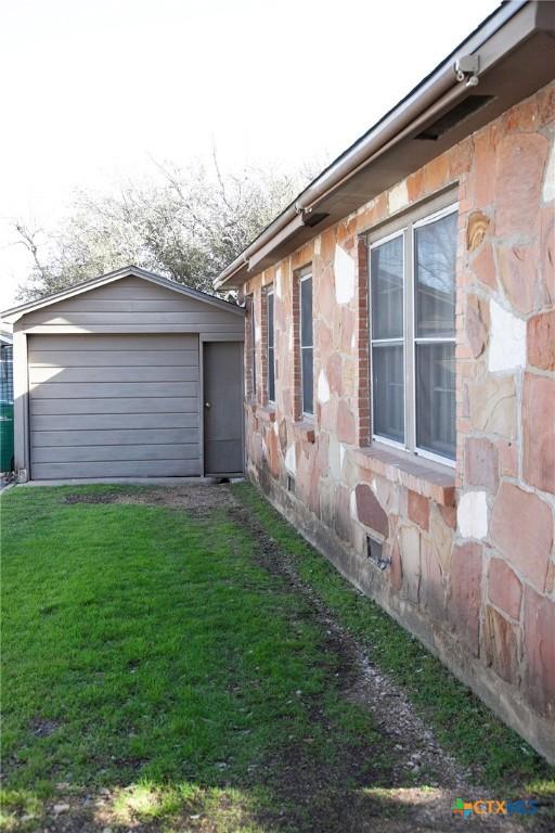 view of home's exterior with a yard and an outbuilding