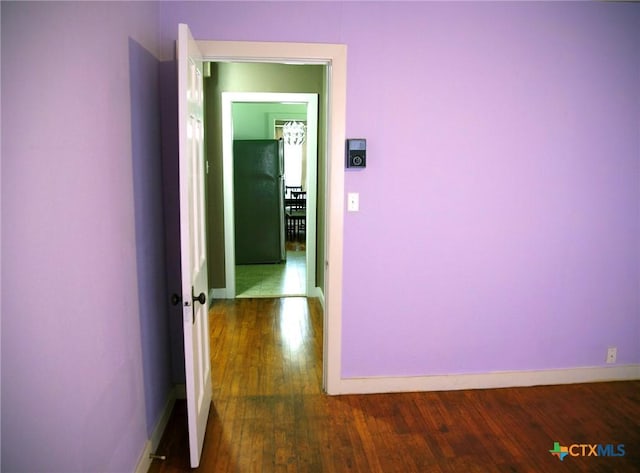 hallway with hardwood / wood-style flooring and baseboards