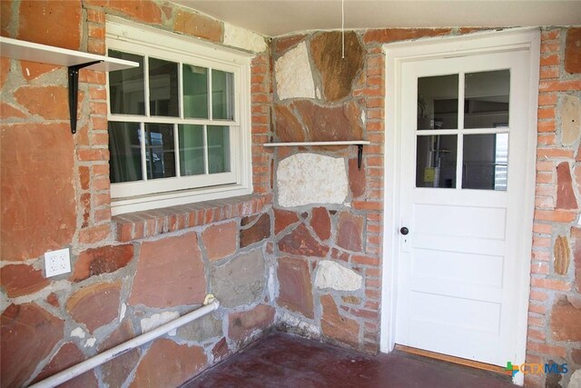 doorway to property with brick siding