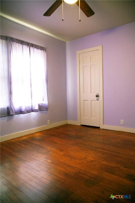 unfurnished room featuring ceiling fan, baseboards, and wood finished floors