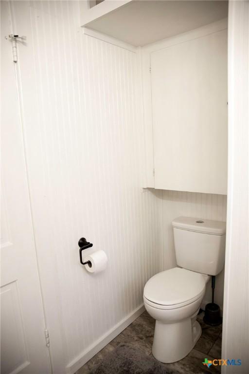 bathroom with toilet and baseboards