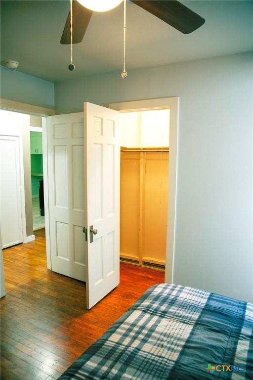 bedroom with a closet, a ceiling fan, and wood finished floors