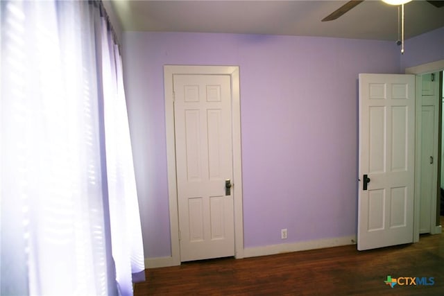 unfurnished bedroom with wood finished floors, baseboards, and ceiling fan