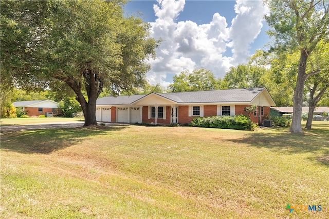 ranch-style home featuring central AC unit, a garage, and a front yard